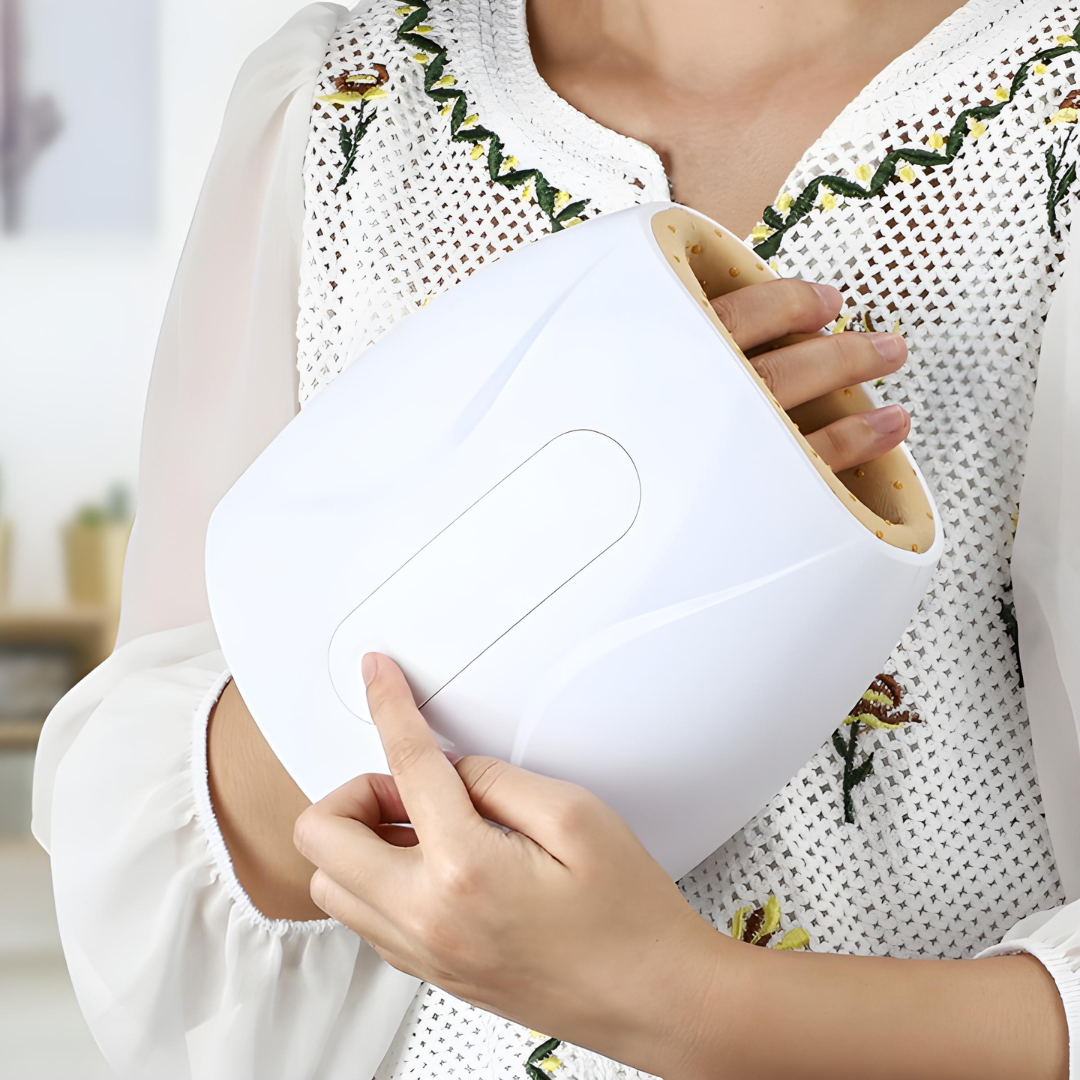 Close-up of woman using white cordless hand massager with heat and air compression for at-home wrist and palm relief