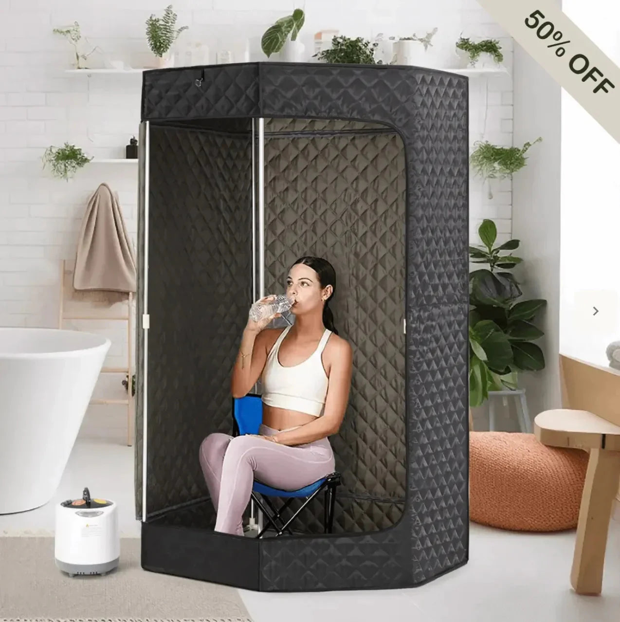 A woman sitting in a portable sauna, drinking water, with a modern interior background.
