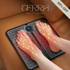 Person using EMS foot massager pad with muscle stimulation for pain relief, improved circulation, and foot relaxation at home