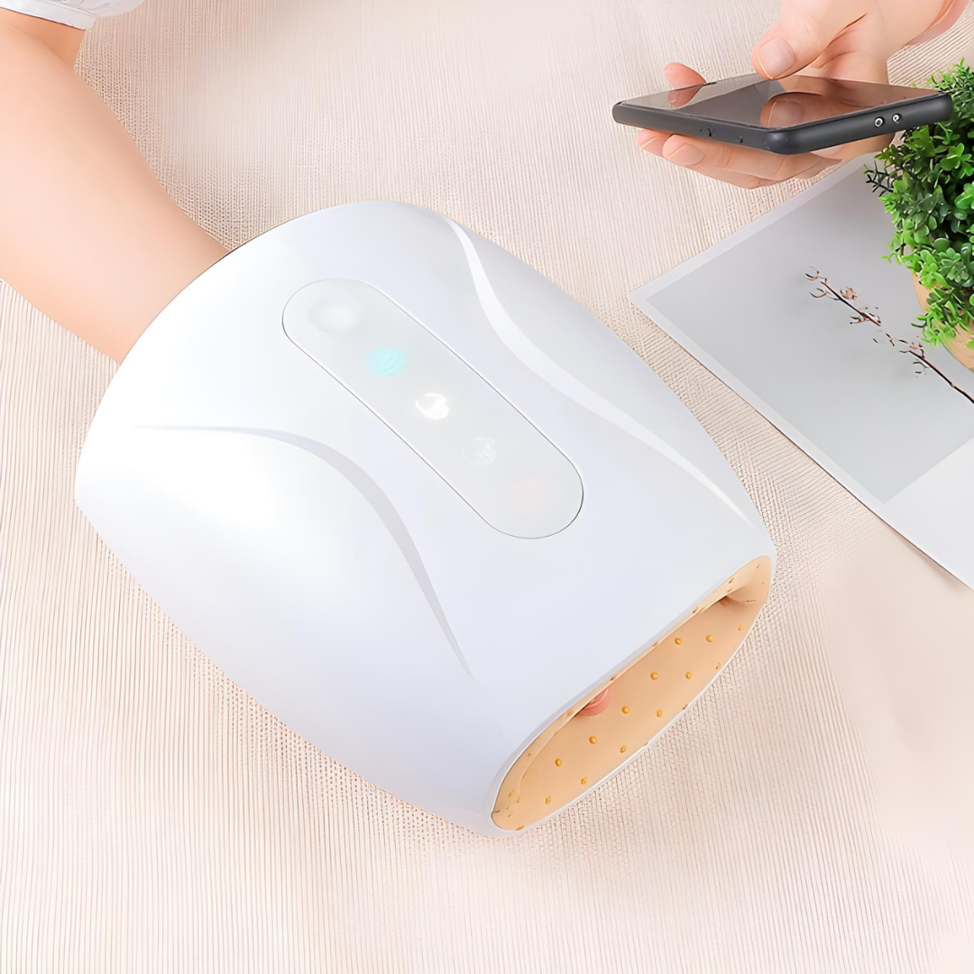 White cordless hand massager in use on a desk, ideal for pain relief, improved circulation, and everyday hand relaxation